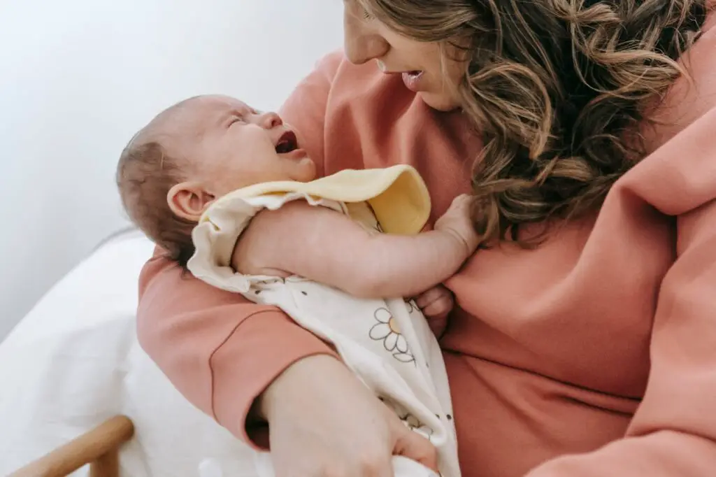 A crying baby in the mother's lap