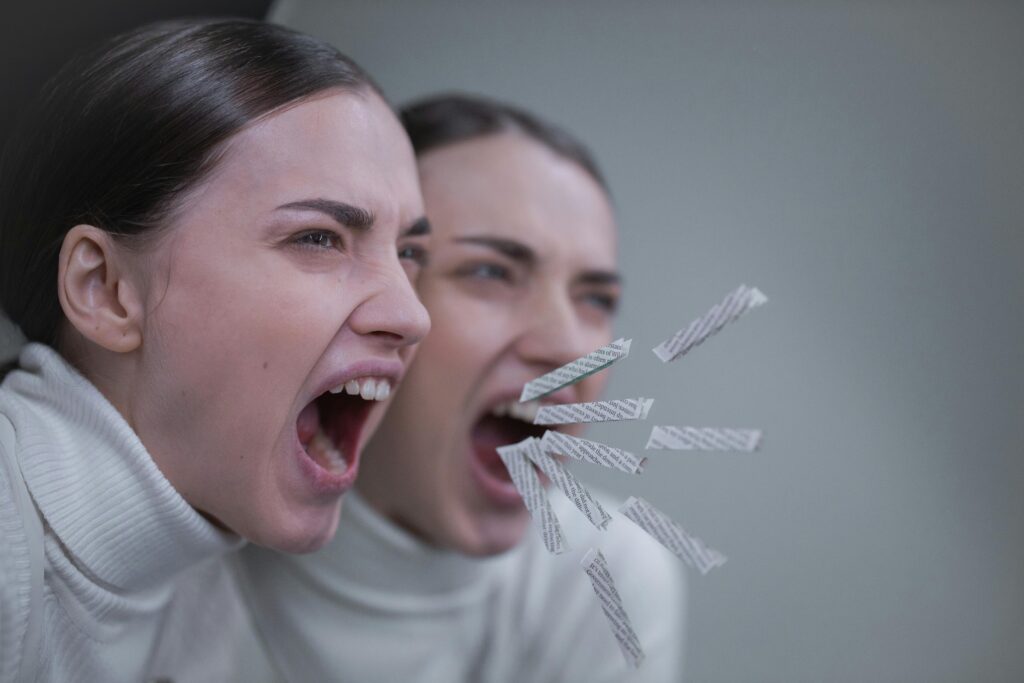 A woman passionately screaming with her reflection in a mirror, artistic concept.